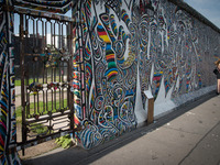 Visitors walk along the East Side Gallery, a mile-long section of the Berlin Wall still standing that is covered in murals and graffiti, on...