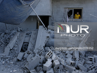A Palestinian man looking from the window at the destruction after a nearby house was hit by an Israeli military strike in Rafah in the sout...