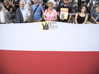 Protesters stand near polish flag during protest against government plans of changes to Poland’s judicial system in Warsaw on July 25, 2017....