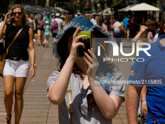 A tourist takes a photo in La Rambla on August 8, 2017,  Barcelona, Spain. In the past year there have been a series of protests as resident...