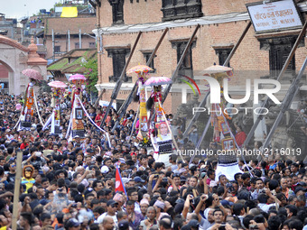Nepalese devotees carry’s the straw effigy as they take part in a procession during Gai Jatra or Cow Festival celebrated in Bhaktapur, Nepal...