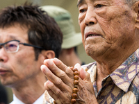  Visitors lays flowers and pray for the atomic bomb victims in front of the Nagasaki Peace Park in Nagasaki, southern Japan on Wednesday, Au...