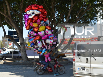 Two men ride a motorcycle as they carry colourful balloons in Adana, Turkey on April 09, 2017. Photo was taken on April 09, 2017. (