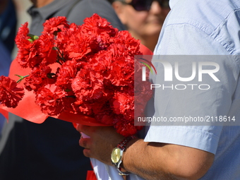 A man holds flowers as families and relatives gathered in front of the central railway station to commemorate the martyrs of Turkey's deadli...