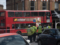 Police Officers, firemen and emergency workers are seen on the scene of a bus accident in southwest London, on August 10, 2017. A double-dec...