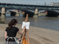A painter is pictured while painting the Blackfriars bridge, in a sunny morning in the Southbank of London, on August 11, 2017. The South Ba...