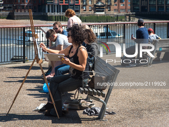 A painter is pictured while painting the Blackfriars bridge, in a sunny morning in the Southbank of London, on August 11, 2017. The South Ba...