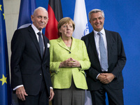 German Chancellor Angela Merkel (C), United Nations High Commissioner for Refugees Filippo Grandi (L) and Director General of the Internatio...