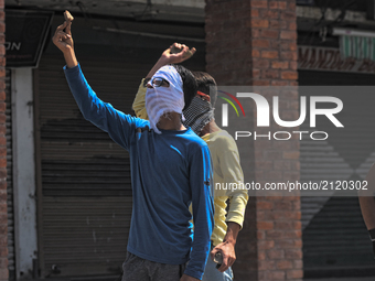  A Kashmiri Muslim protester shows piece of brick to Indian government forces during an anti India protest on August 11, 2017 in Srinagar, t...