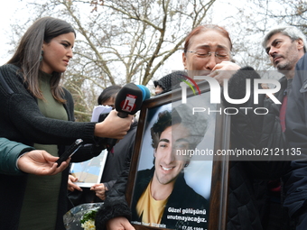 A grieved mother mourns as she holds her son's portrait during a commemoration to the 1st anniversary of the Guven Park bombing in Ankara, T...