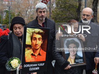Grieved mothers mourn as they hold their sons' portraits during a commemoration to the 1st anniversary of the Guven Park bombing in Ankara,...