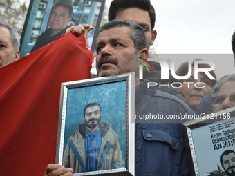 A grieved father mourns as he holds his son's portrait during a commemoration to the 1st anniversary of the Guven Park bombing in Ankara, Tu...