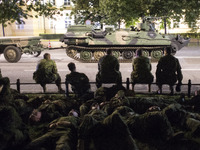 Soliders rest during night training before parade on Polish Army Day in Warsaw on August 12, 2017. (