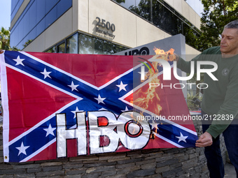 Activists burn a Confederate flag with the HBO logo in protest of HBO’s new series in development, Confederate. Santa Monica, California on...