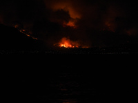 Massive wildfire with multiple front burning houses at Kalamos Attika, scene shot from a distance of 5 km in Amarynthos, Eretria on Euboea o...