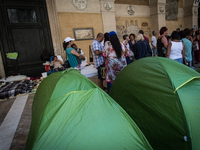  Migrant families with children during a press conference in the colonnade of the busy basilica where dozens of families have lived since be...
