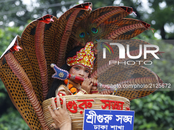 A couple poses as Sri Krishna and Radha on a peacock like float in a procession marking Janmashtami in Dhaka, Bangladesh on 14 August, 2017....
