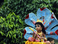 A couple poses as Sri Krishna and Radha on a peacock like float in a procession marking Janmashtami in Dhaka, Bangladesh on 14 August, 2017....