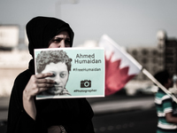 Bahrain , Duraz - female protester holding a freelance photojournalist picture duing a sit in with detainee photographers and journalists ,...