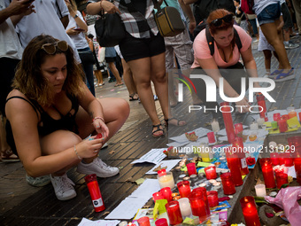 Two women light  candles in Las Ramblas of Barcelona, Spain, on 18 August 2017, to pay tribute to the victims a day after a van ploughed int...