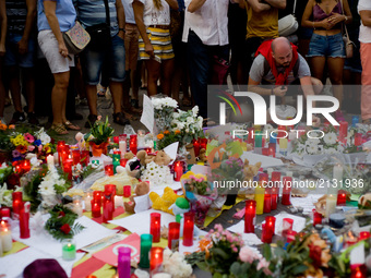 A man  lights  candles in Las Ramblas of Barcelona, Spain, on 18 August 2017, to pay tribute to the victims a day after a van ploughed into...
