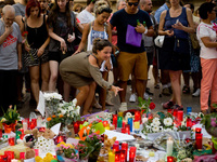 A woman throws a rose among the candles  in Las Ramblas of Barcelona, Spain, on 18 August 2017, to pay tribute to the victims a day after a...