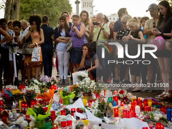 People  stands next to candles and flowers  in Las Ramblas of Barcelona, Spain, on 18 August 2017, to pay tribute to the victims a day after...