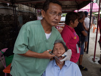 A patient reacts as he is injected with dental anaesthesia by a dentist prior to a tooth extraction during a medical mission at a village in...