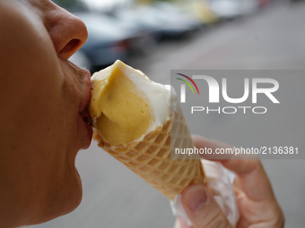 A woman is seen eating mango flavoured ice cream in a gluten free cone on 19 August, 2017. (
