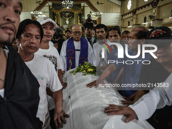 Catholic priests, relatives, and friends push the coffin of Kian Loyd Delos Santos during his funeral rites in Caloocan, Metro Manila, Phili...