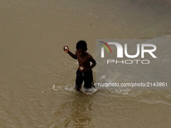 A rag picker holds a coconut and eats it after collecting from the river water inside the river Kuakhai as they are busy to collect reusable...