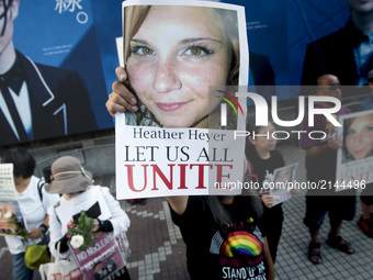 People holds a photo of Heather Heyer during the standing silent appeal, a hundred people gathered in shibuya against racism and violence in...