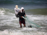 A Palestinian fisherman casts his net as he wades on the surf off on August 17, 2014 .Israeli Prime Minister Benjamin Netanyahu  Israel will...