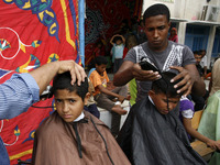 RAFAH, GAZA STRIP, PALESTINE - AUGUST 17:  Palestinians displaced shave their hair as they gather in an UNRWA school in Rafah in the souther...