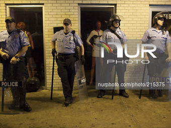 Ferguson Police wait by shops along W. Florissant Ave in Ferguson, during a protest for the killing of teenager Michael Brown on August 17,...