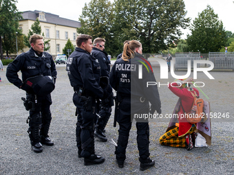 Policemen stand on front of a right-wing counter protester who is dressed as a clown  in Wurzen, Germany on 2 September 2017. About 400 peop...