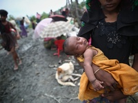 A rohingya woman waits with her new born child to cross the border at Mongdaw, Myanmar on September 6, 2017.  Rohingya are a Muslim ethnic m...