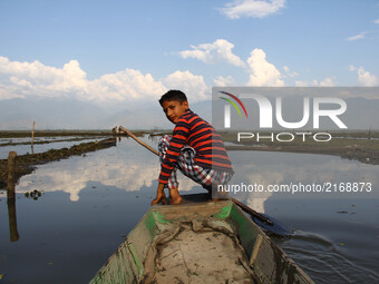 Amir, a 7th class student ready to row his boat in the Wular Lake, 60 km north of Srinagar.  It is sited in Bandipora district in the Indian...