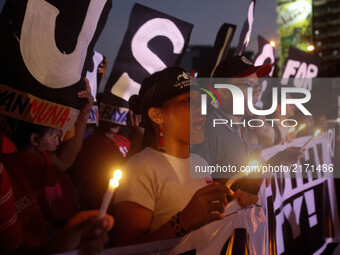 Protesters holding candles shout slogans during a rally against extrajudicial killings allegedly done by government forces and vigilantes in...