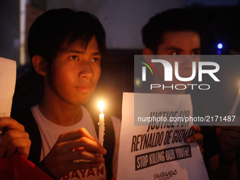 Protesters hold candles and placards during a rally against extrajudicial killings allegedly done by government forces and vigilantes in Man...