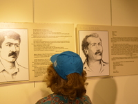 A woman looks at portraits of the victims on the opening day of the September 12 Shame Museum, which is held with the help of the main oppos...
