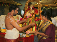 Tamil Hindu priest blesses women participating in special prayers during Varalaxmi Pooja (Varamahalakshmi Vrata) at a Tamil Hindu temple in...