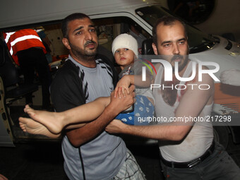 Palestinians convey a wounded man to Al-Shifa hospital after Israeli warplanes targeted the house of Al-Dalow family in Al-Sheikh redwan are...