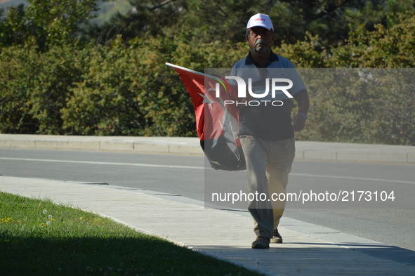 A man walks with a Turkish flag during a march marking the 94th anniversary of the main opposition Republican People's Party (CHP) at Anitka...