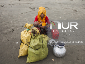 A Rohingya ethnic minority woman cradles her child at the see beach after crossing over from Myanmar into the Bangladesh side of the border,...