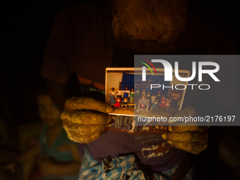 Rohingya Muslim elderly shohing his familys photo at a temporary makeshift shelters after crossing over from Myanmar into the Bangladesh sid...