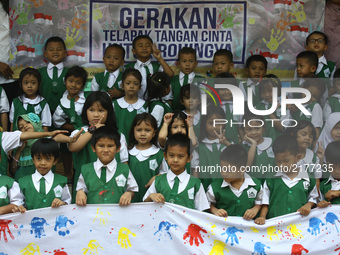 At-Taqwa kindergarten students put their hand prints with colorful watercolors on white cloths in Jakarta, September 11, 2017. The handprint...