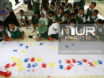 At-Taqwa kindergarten students put their hand prints with colorful watercolors on white cloths in Jakarta, September 11, 2017. The handprint...
