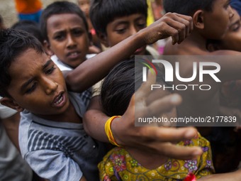 Rohingya Muslim refugees wait for relief near a camp at a temporary makeshift shelters after crossing over from Myanmar into the Bangladesh...