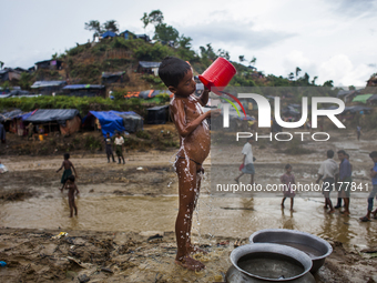 Rohingya Muslim refugees are taking shower at a temporary makeshift shelters after crossing over from Myanmar into the Bangladesh side of th...
